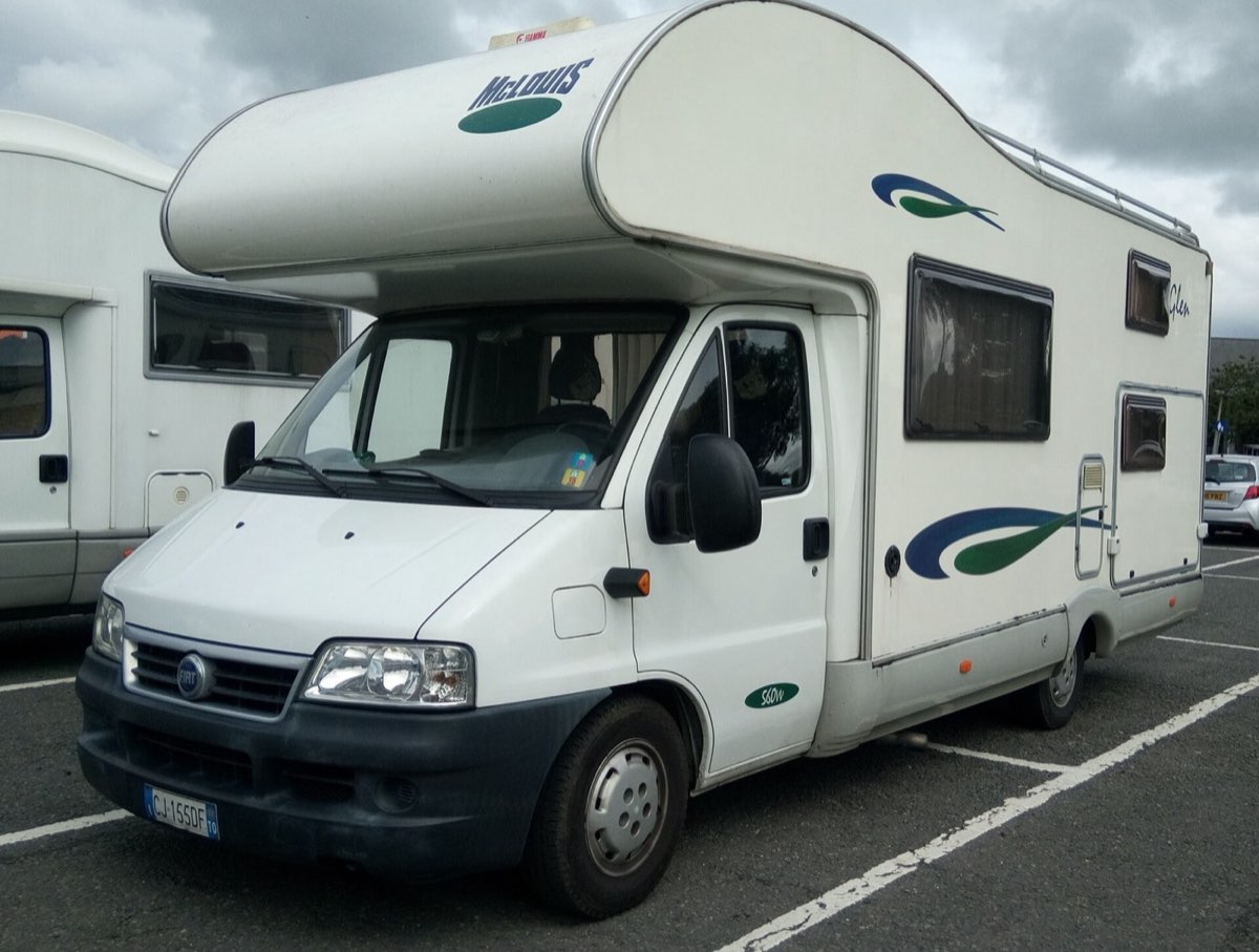 A campervan parked at a scenic pullout with a mountain view