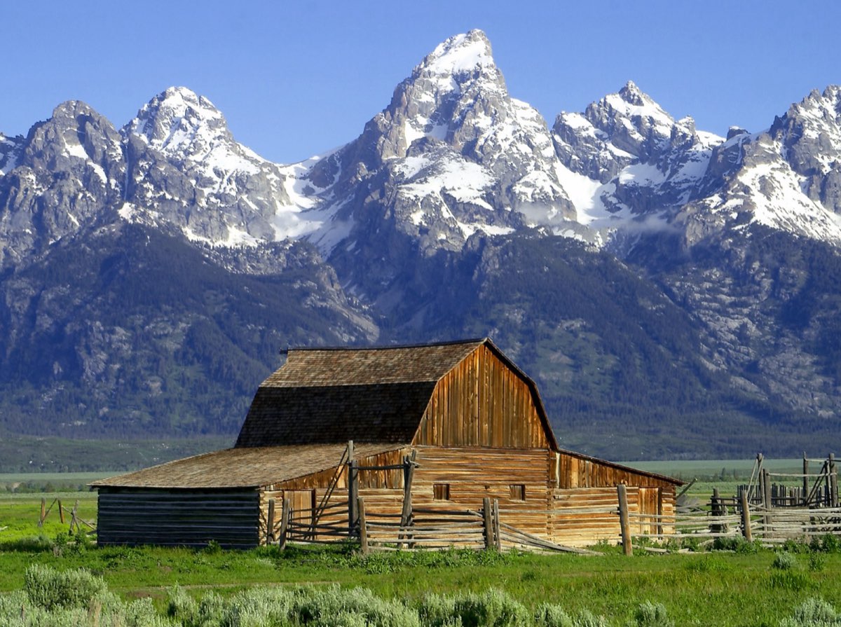 The Teton range rising sharply above a valley and a winding river