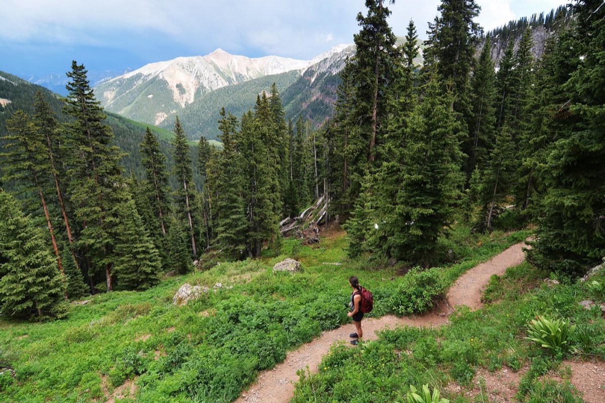 A hiker with a large pack on a high mountain trail