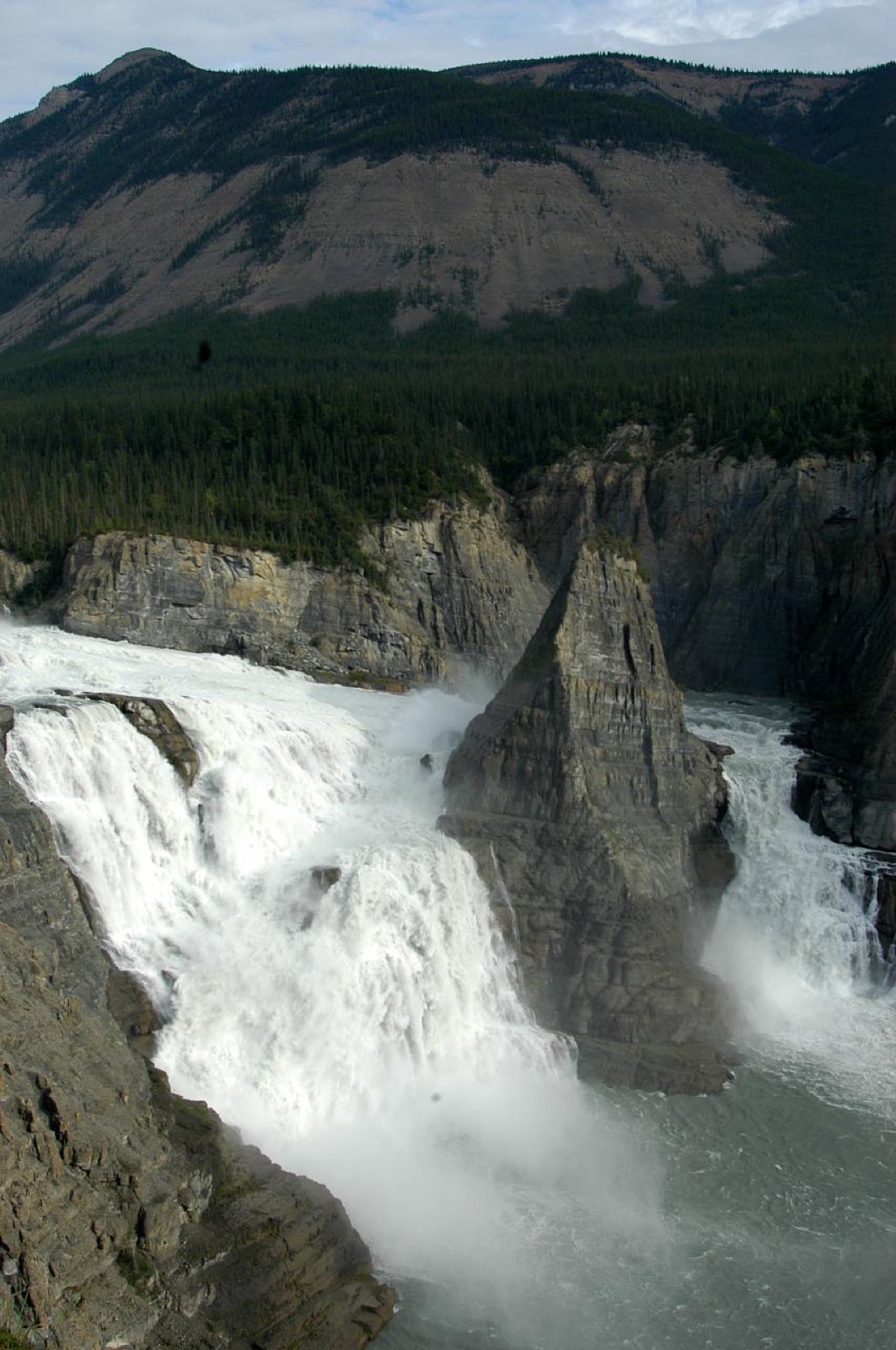 Virginia Falls thundering around its central rock spire on the South Nahanni River